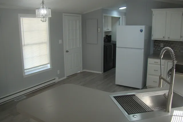 a view of kitchen with refrigerator cabinets and wooden floor