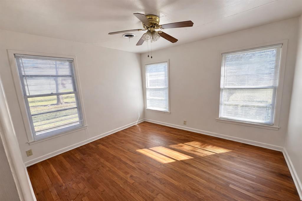 809 Crescent Street Denton, TX 76201 - Photo 13 of 24 a view of an empty room with a window and wooden floor