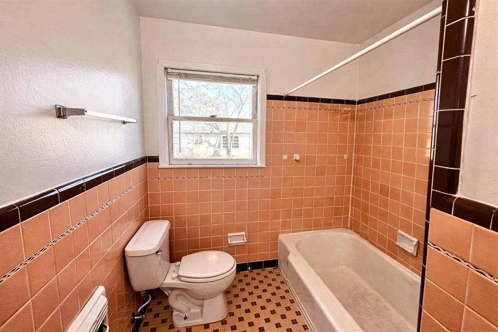 809 Crescent Street Denton, TX 76201 - Photo 18 of 24 a bathroom with a toilet a sink and bathtub