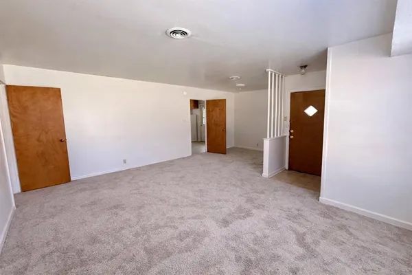 an empty room with closet and mirror