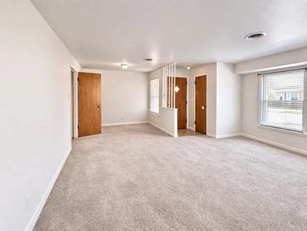 an empty room with windows and closet