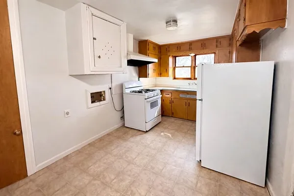 a view of a kitchen with cabinets and a refrigerator
