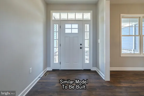 an empty room with wooden floor painted walls and windows