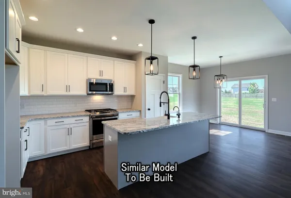 a kitchen with kitchen island granite countertop a stove a sink a refrigerator and a microwave