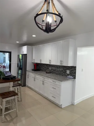 a kitchen with stainless steel appliances granite countertop a sink a stove and a refrigerator