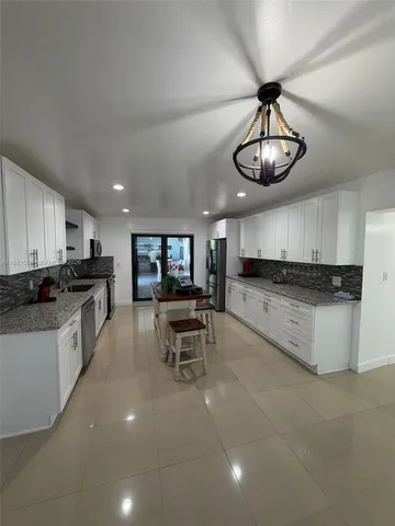 a kitchen with stainless steel appliances kitchen island granite countertop a stove and a sink with granite countertops