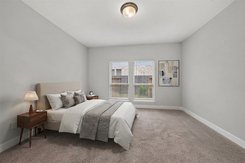 4207 Ana Ridge Lane Fulshear, TX 77441 - Photo 21 of 37 Sunlit downstairs guest bedroom featuring plush carpet and crisp, inviting finishes—a cozy and welcoming sanctuary for visiting family or guests! (virtual staging)