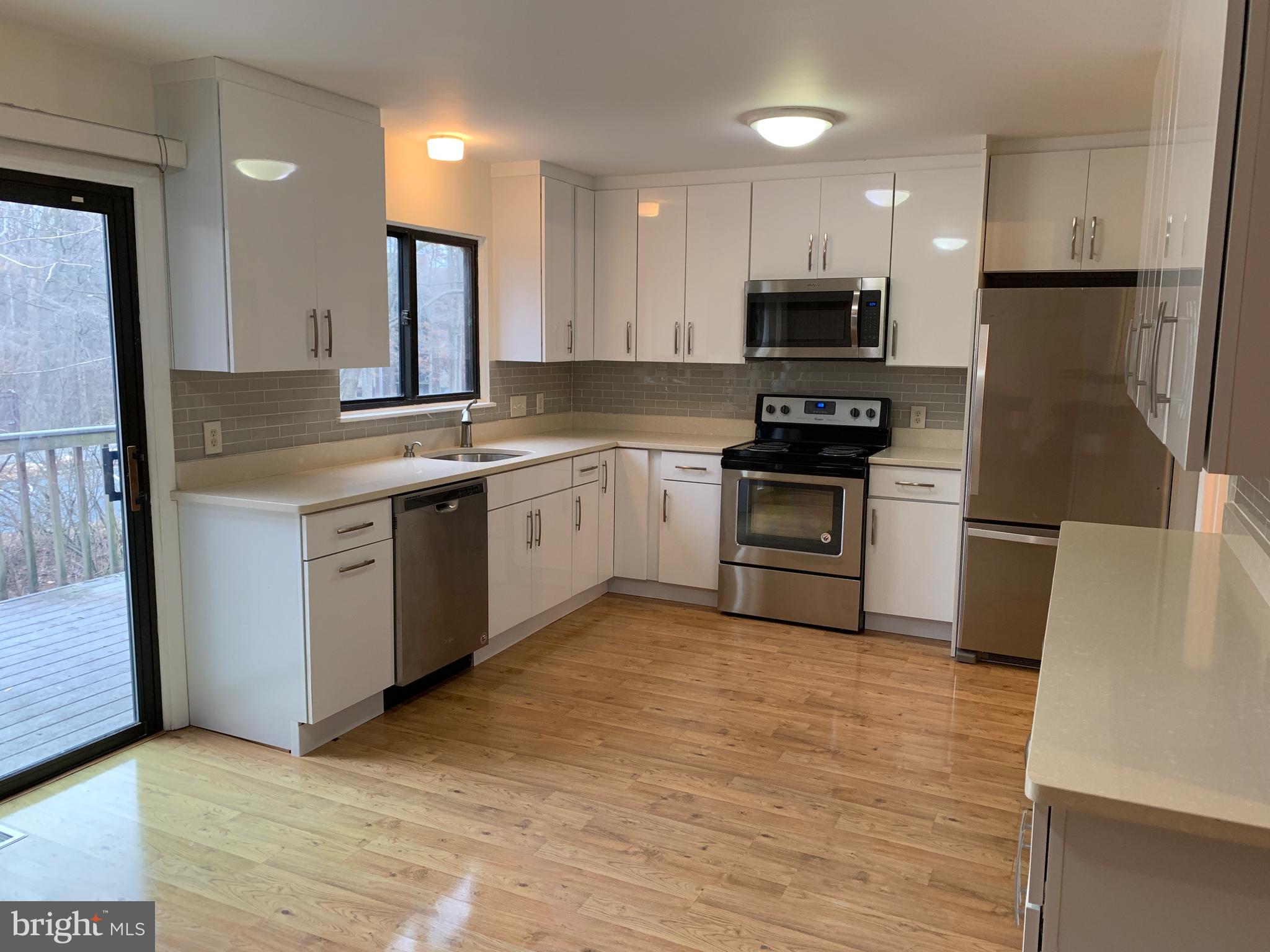 11969 Greywing Court Reston, VA 20191 - Photo 2 of 4 a kitchen with stainless steel appliances granite countertop a stove top oven a sink and a refrigerator