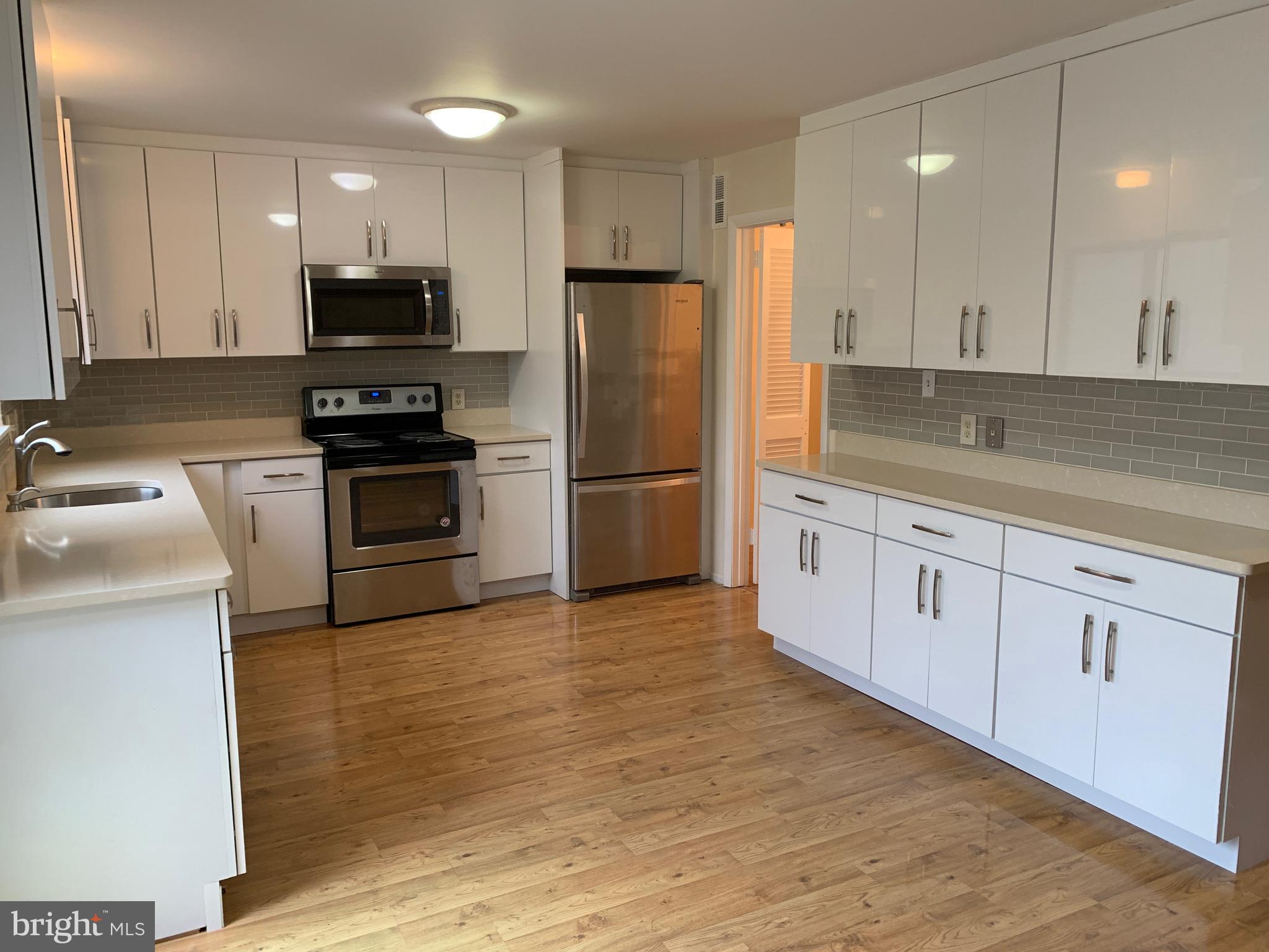 11969 Greywing Court Reston, VA 20191 - Photo 3 of 4 a kitchen with cabinets stainless steel appliances and wooden floor