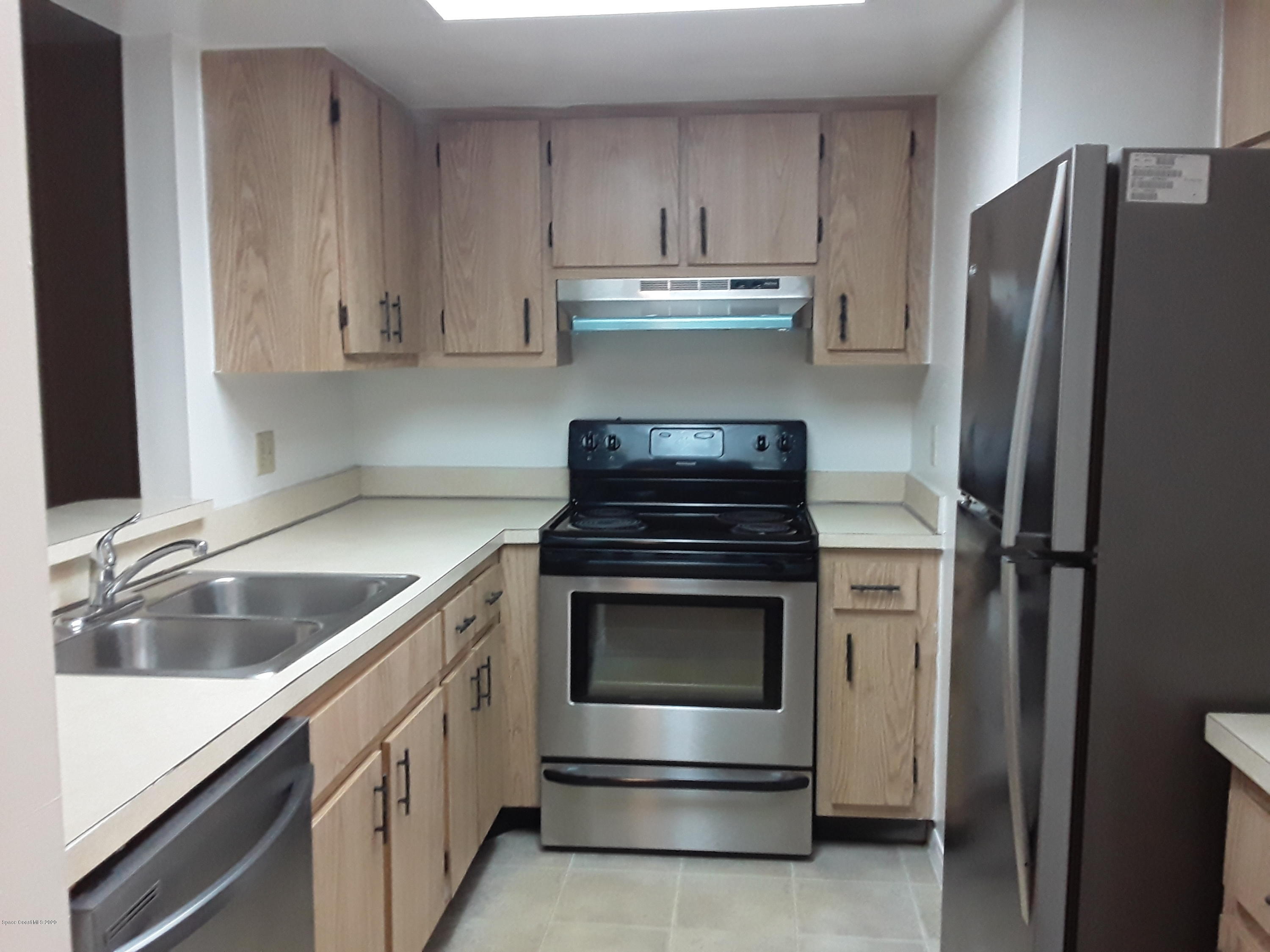 1049 June Drive Melbourne, FL 32935 - Photo 7 of 12 a kitchen with stainless steel appliances granite countertop a refrigerator and a sink