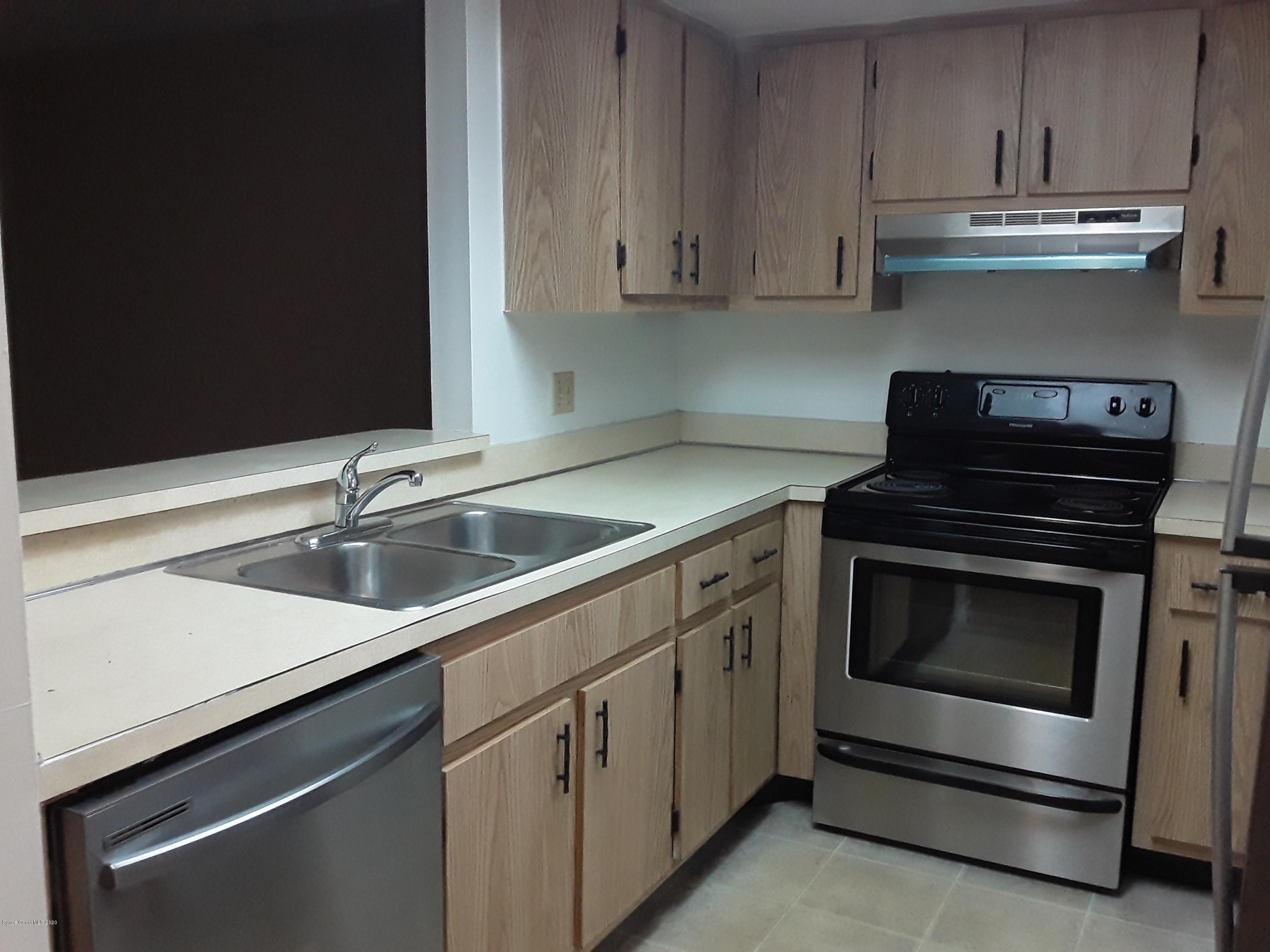 1049 June Drive Melbourne, FL 32935 - Photo 8 of 12 a kitchen with granite countertop white cabinets and stainless steel appliances