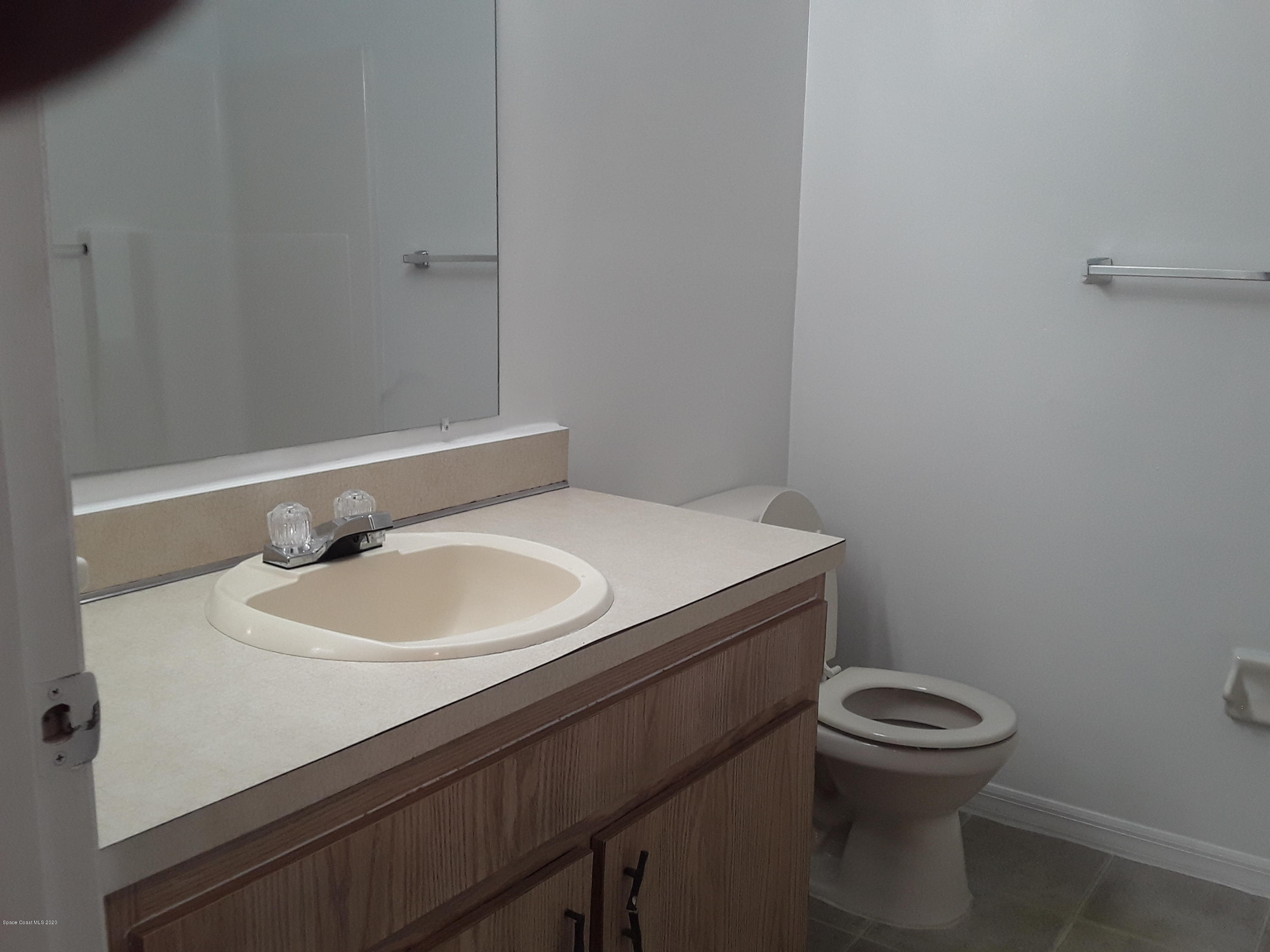 1049 June Drive Melbourne, FL 32935 - Photo 9 of 12 a bathroom with a sink a toilet and a mirror
