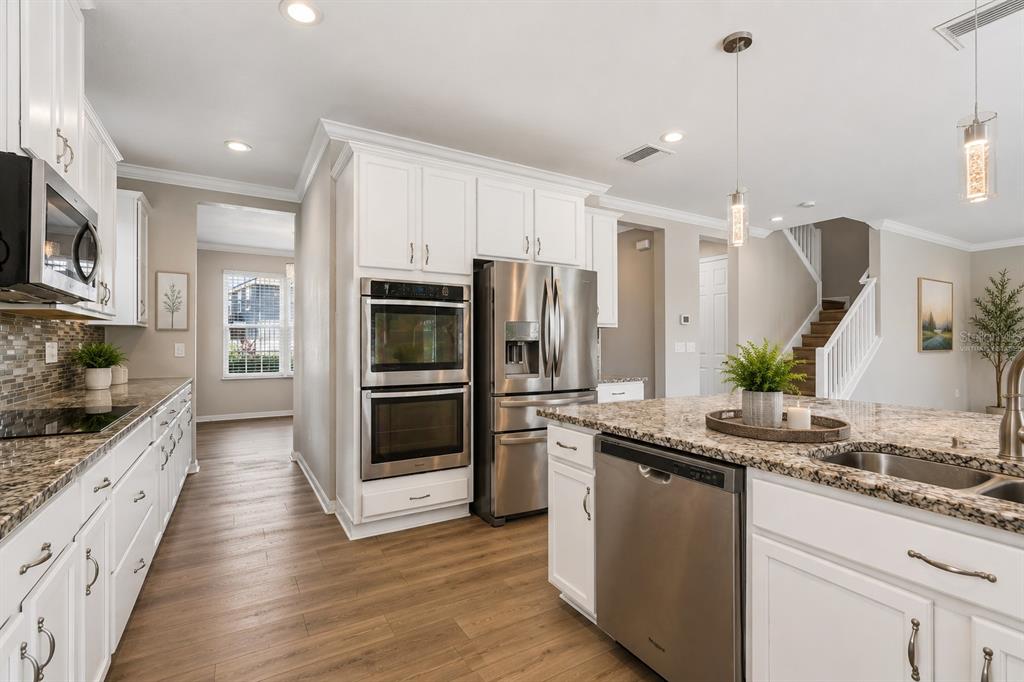 1192 Multiflora Loop Lutz, FL 33558 - Photo 10 of 32 a kitchen with stainless steel appliances a sink a stove cabinets and a wooden floor