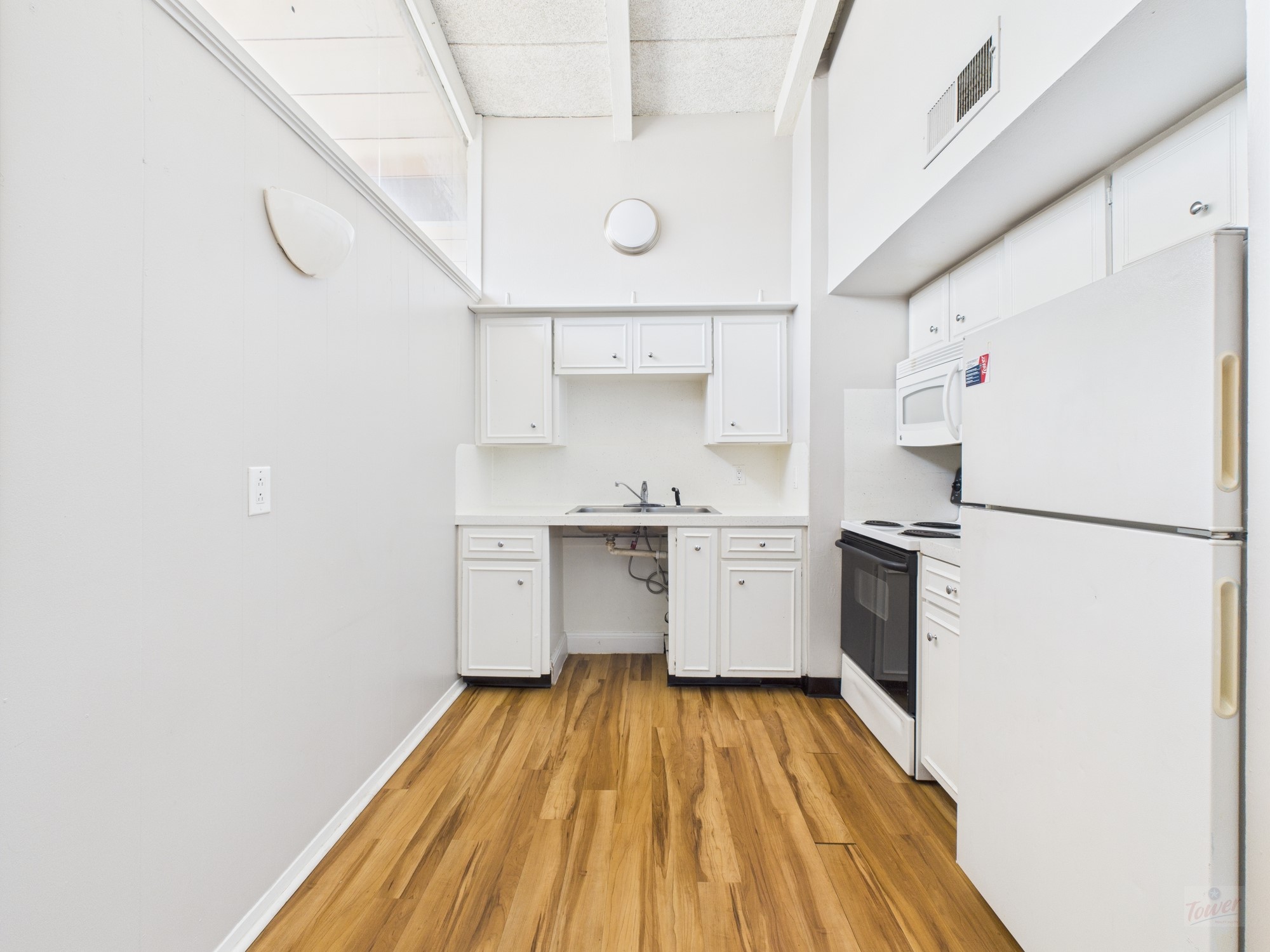 2404 Longview Street, Unit 206 Austin, TX 78705 - Photo 18 of 28 a kitchen with a sink a refrigerator and wooden floor