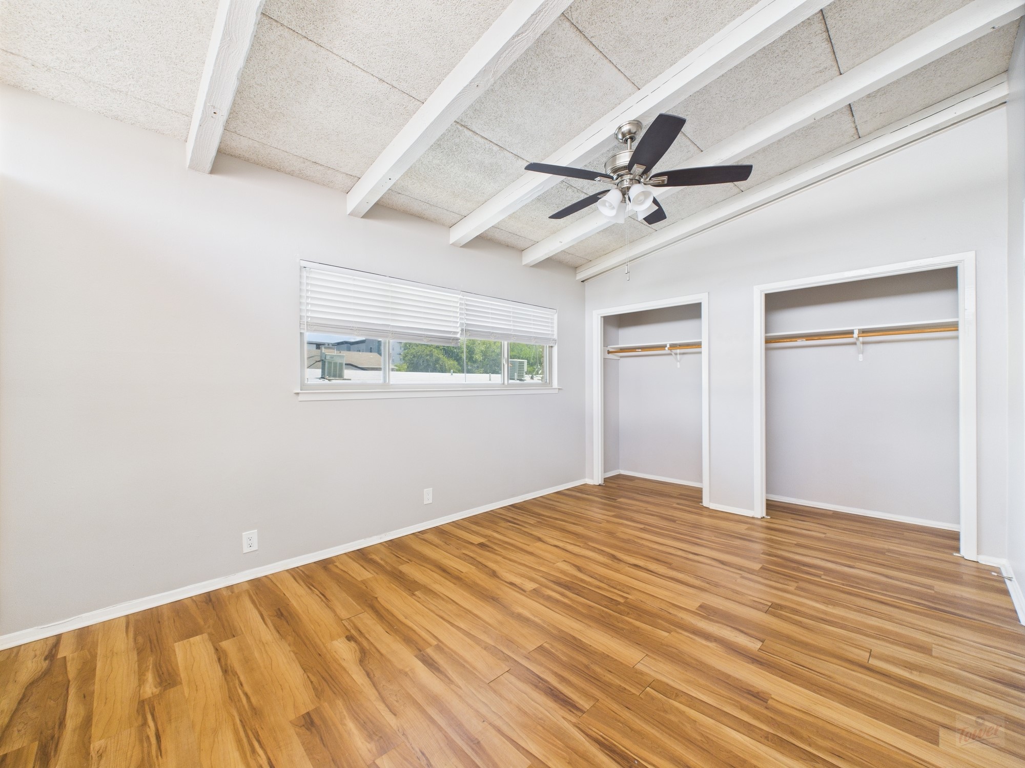 2404 Longview Street, Unit 206 Austin, TX 78705 - Photo 3 of 28 an empty room with wooden floor ceiling fan and windows