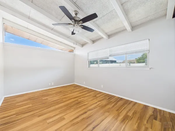 a view of empty room with wooden floor