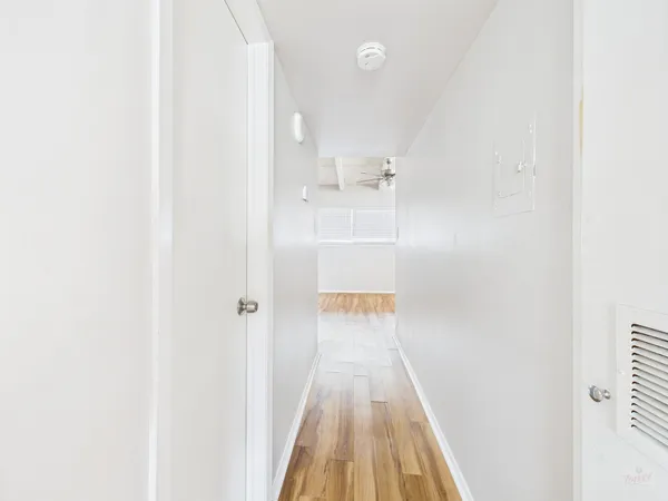a view of a hallway with wooden floor