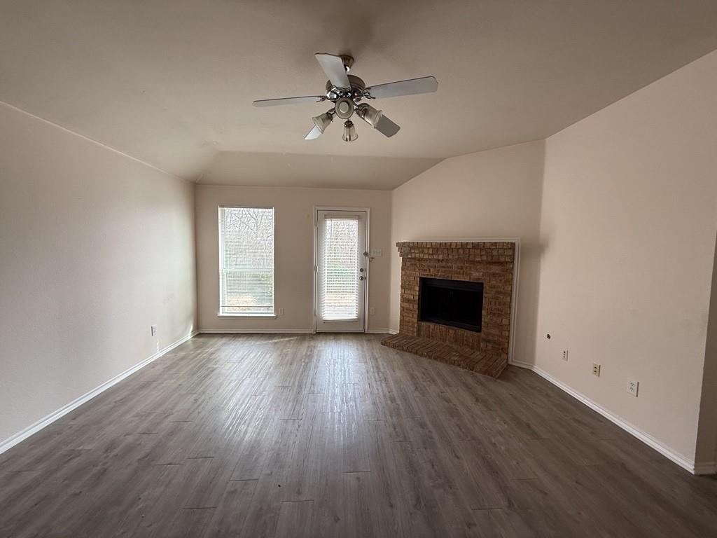 2224 Hummingbird Way Mesquite, TX 75181 - Photo 2 of 28 an empty room with wooden floor fireplace and windows