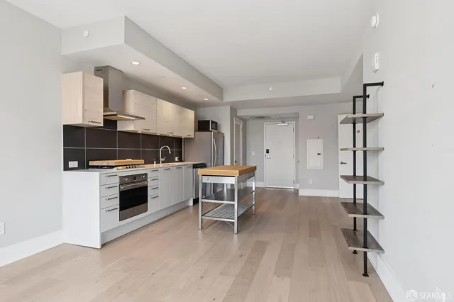 a kitchen with a refrigerator and a stove top oven