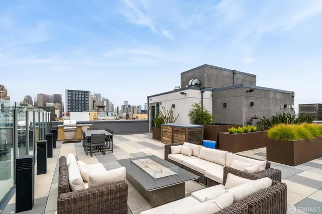 a view of a roof deck with couches and potted plants
