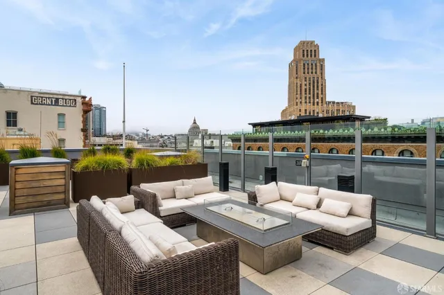 a view of a roof deck with couches and potted plants
