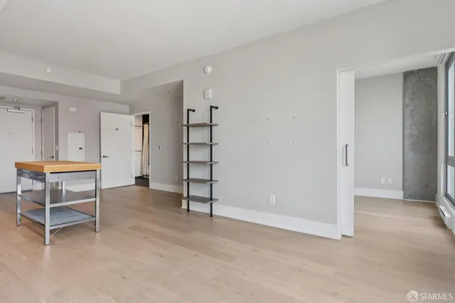 a view of an empty room with cabinet and entryway