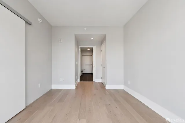 a view of a room with wooden floor and a window