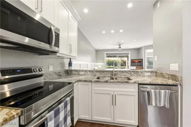 a kitchen with stainless steel appliances granite countertop a sink and stove top oven