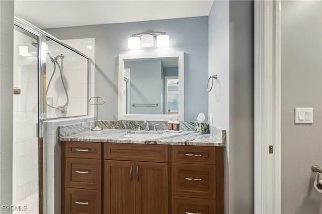 a bathroom with a granite countertop sink vanity and mirror