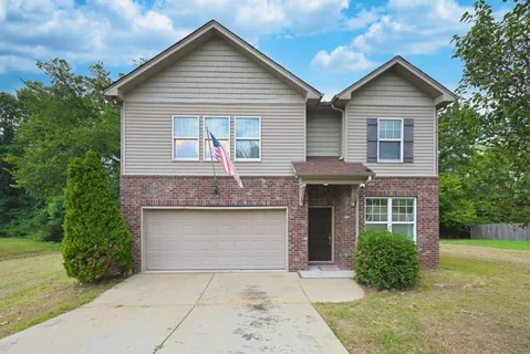 a front view of a house with yard and green space