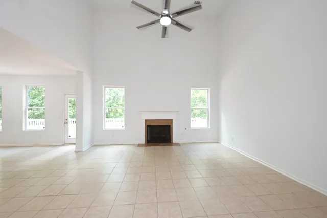 an empty room with fireplace and windows