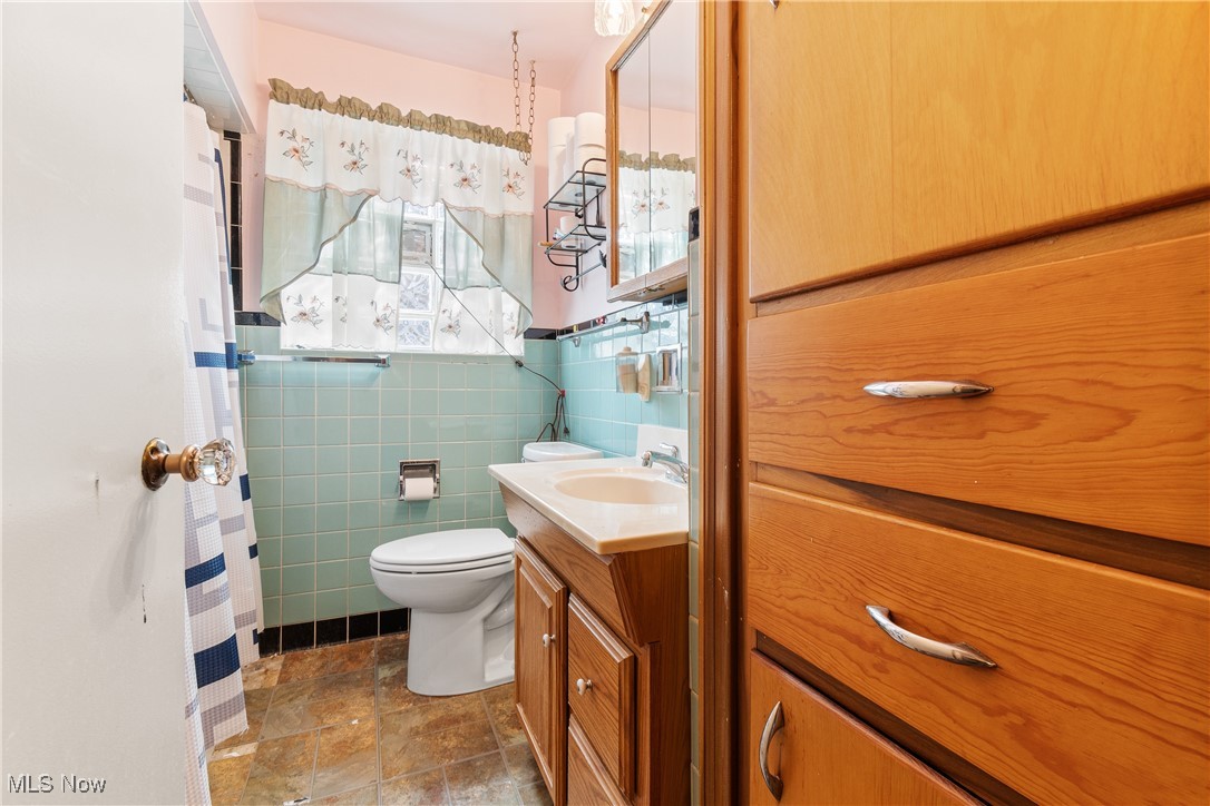 1527 Ridge Road Northwest Canton, OH 44703 - Photo 16 of 27 Bathroom with vanity, tile walls, and toilet