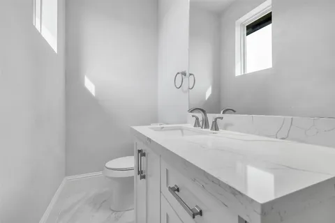 a bathroom with a sink a toilet and a mirror