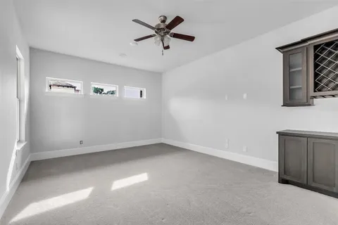 an empty room with a ceiling fan and wooden floor