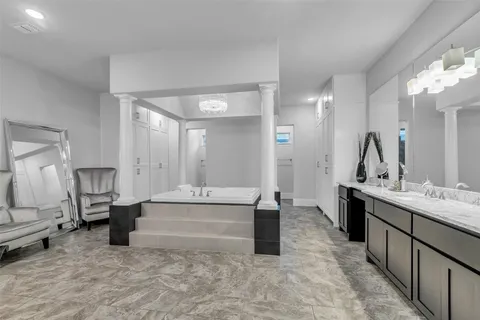a large white kitchen with sink and cabinets