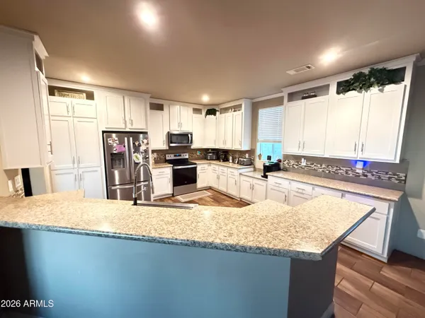 a kitchen with granite countertop a sink stove and refrigerator