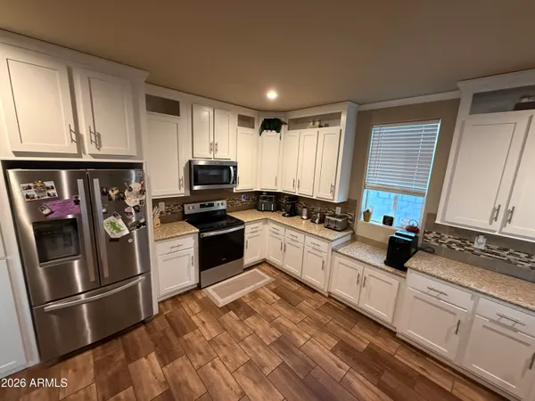 a kitchen with granite countertop a refrigerator stove and sink