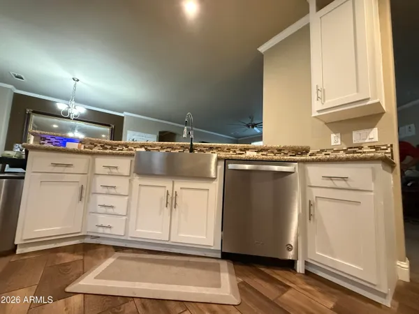 a kitchen with granite countertop a sink cabinets and stainless steel appliances