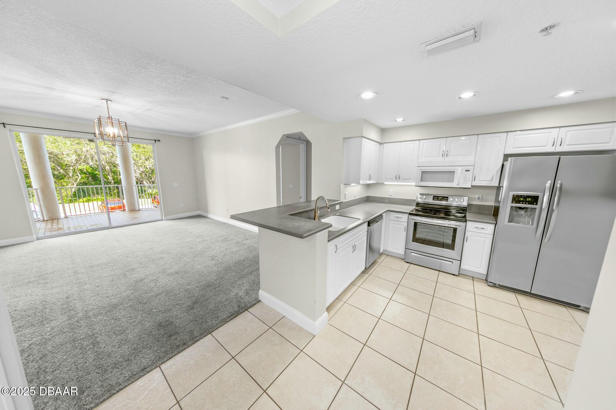 4623 Rivers Edge Village Lane, Unit 6204 Ponce Inlet, FL 32127 - Photo 3 of 51 a kitchen with stainless steel appliances granite countertop a stove a sink and a refrigerator