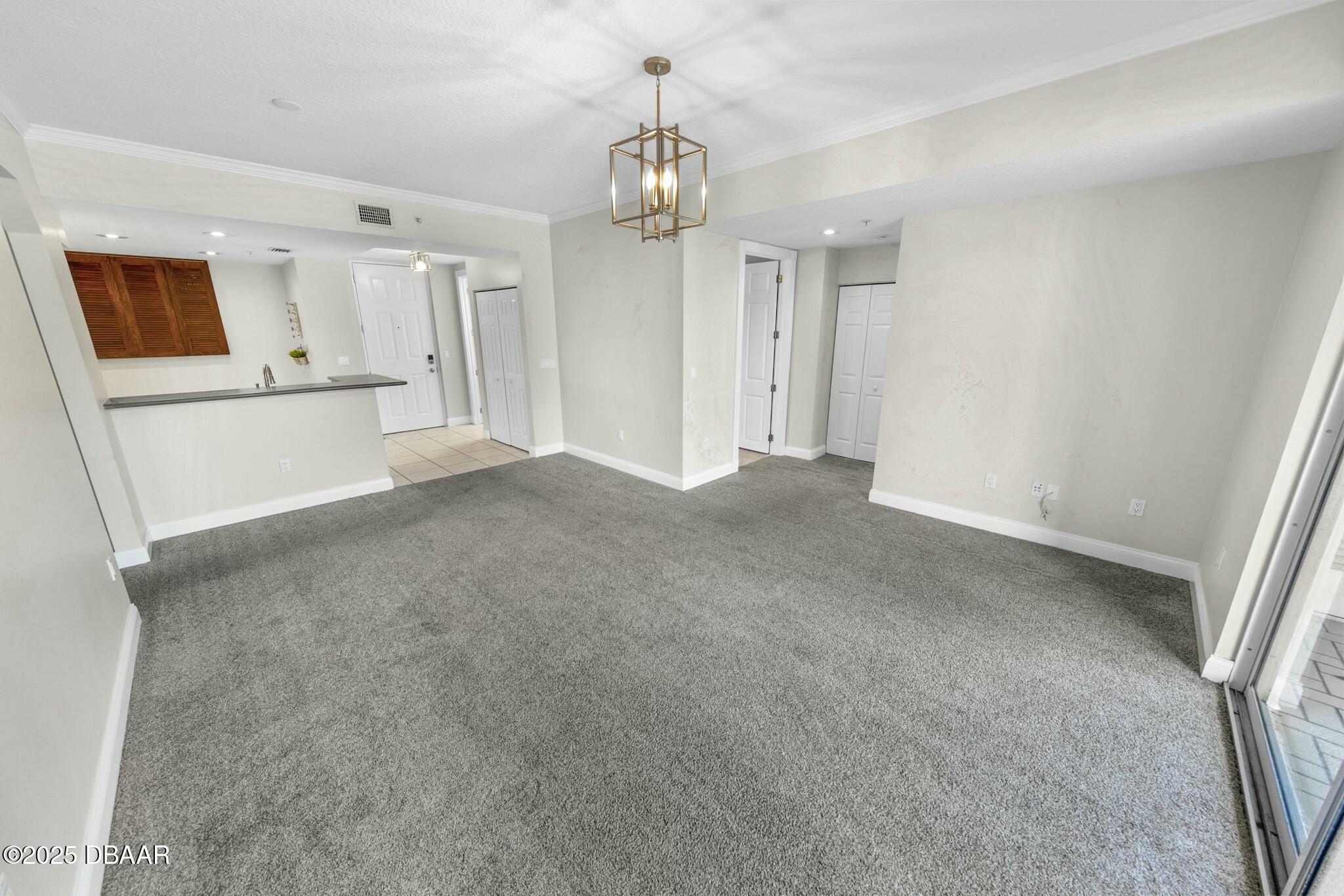 4623 Rivers Edge Village Lane, Unit 6204 Ponce Inlet, FL 32127 - Photo 5 of 51 a view of a hallway with wooden floor and chandelier