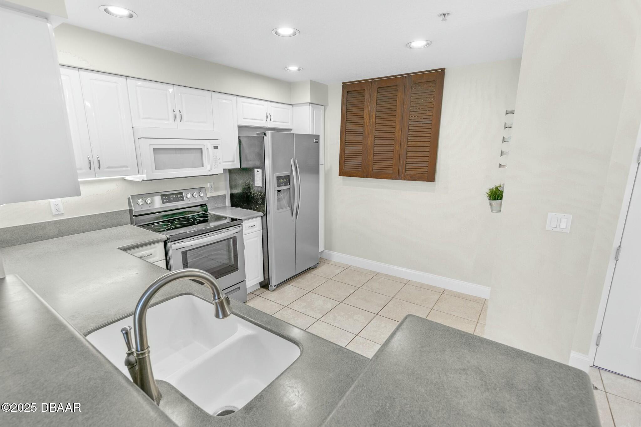 4623 Rivers Edge Village Lane, Unit 6204 Ponce Inlet, FL 32127 - Photo 7 of 51 a kitchen with stainless steel appliances a refrigerator and a stove top oven