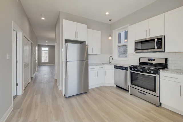a kitchen with stainless steel appliances a refrigerator stove and microwave