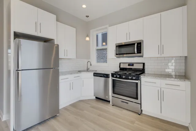 a kitchen with stainless steel appliances granite countertop a refrigerator stove a sink and a microwave