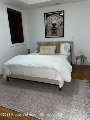 a bedroom with a bed and a painting on the wall