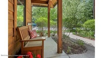 a view of two chairs and a table in the patio