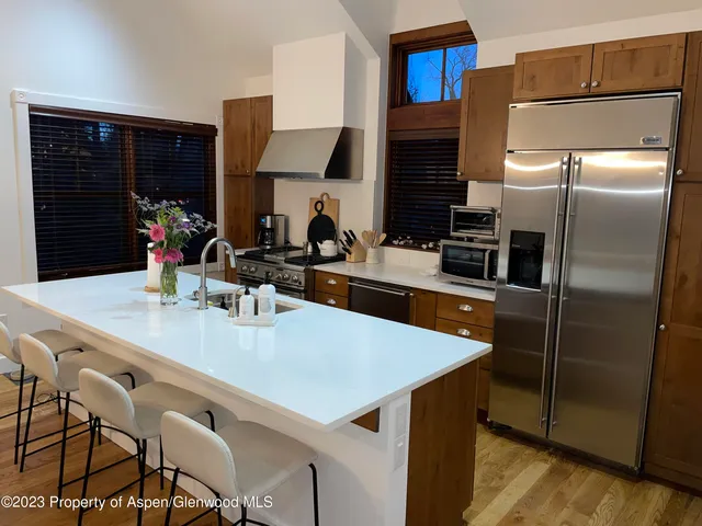 a kitchen with stainless steel appliances a sink a refrigerator and a refrigerator