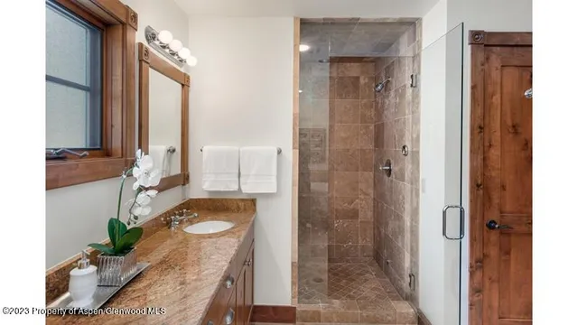 a bathroom with a tub shower sink and mirror