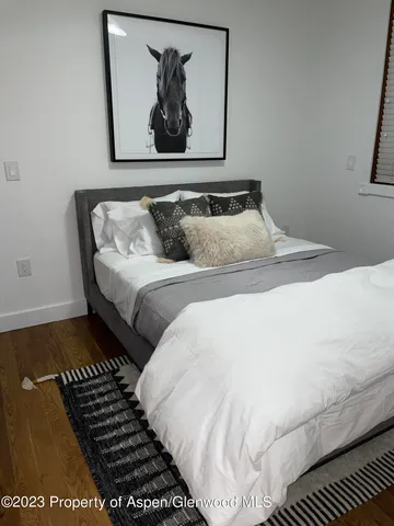 a bedroom with bed and wooden floor