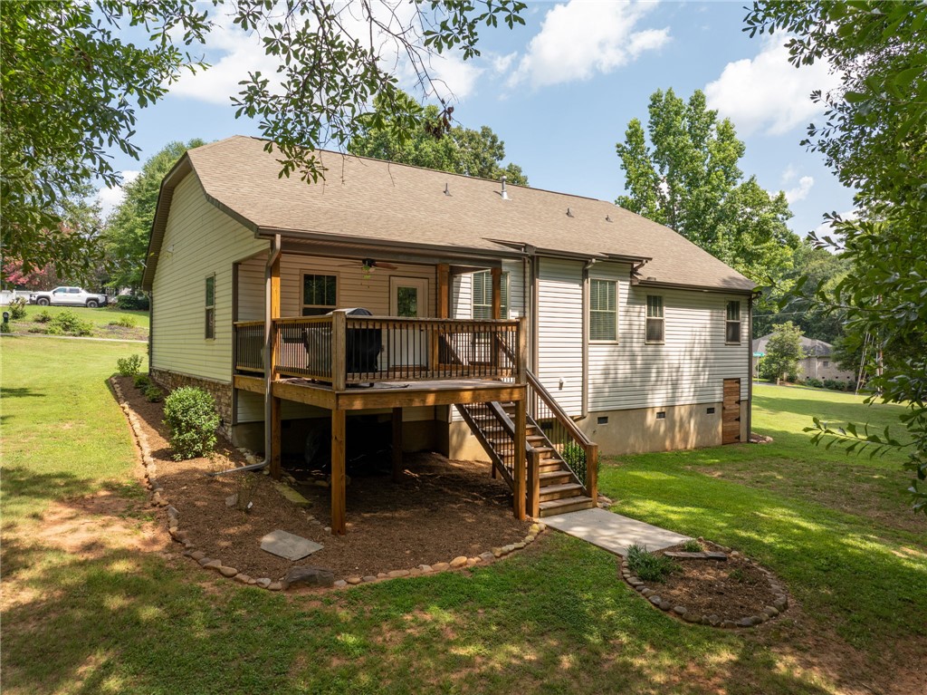 201 Hearthstone Drive Anderson, SC 29621 - Photo 6 of 49 A spacious elevated deck with stairs descends to a verdant yard, framed by mature trees.