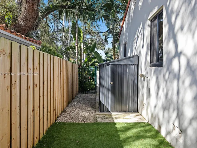 a view of backyard with potted plant and a large trees